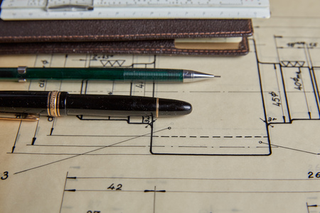 Old technical plan with ruler and pen on old wooden tableの写真素材