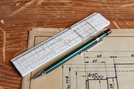 Old technical plan with ruler and pen on old wooden table