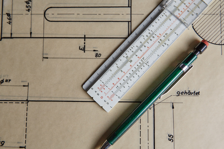 Old technical plan with ruler and pen on old wooden tableの写真素材