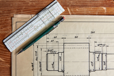 Old technical plan with ruler and pen on old wooden tableの写真素材