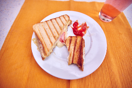 Toast with ham and cheese and ketchup on a kitchen tableの写真素材