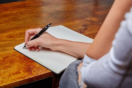 Woman writing in a book with a fountain penの写真素材
