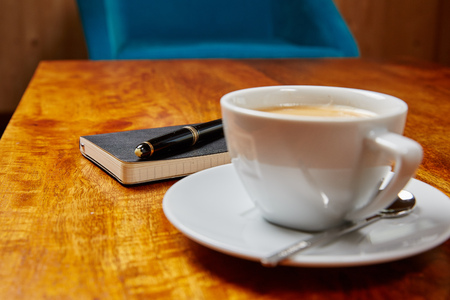 Book, Fountain Pen and Coffee on a wooden Tableの写真素材