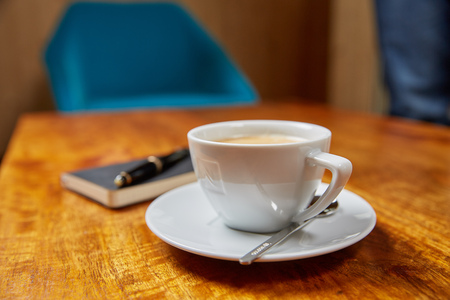 Book, Fountain Pen and Coffee on a wooden Tableの写真素材