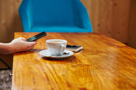 Woman with mobile phone, coffee and notepad  in cafeの写真素材
