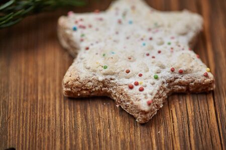 Christmas cinnamon stars and a fir branch on a wooden tableの写真素材