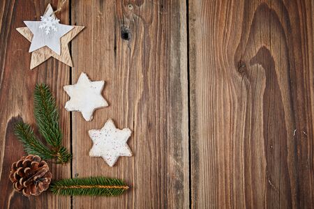 Christmas cinnamon stars and a fir branch on a wooden tableの写真素材