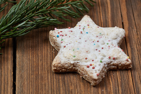 Christmas cinnamon stars and a fir branch on a wooden tableの写真素材