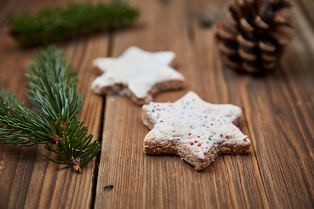 Christmas cinnamon stars and a fir branch on a wooden tableの写真素材