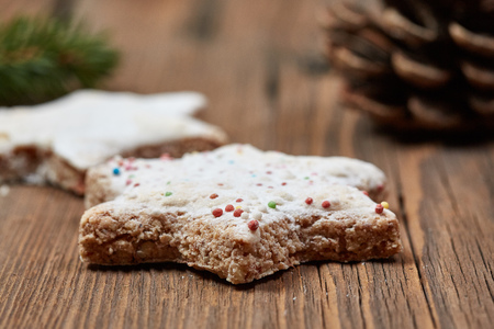 Christmas cinnamon stars and a fir branch on a wooden tableの写真素材