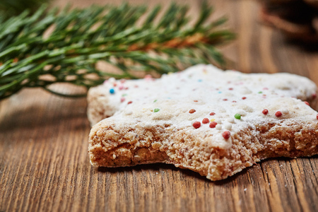 Christmas cinnamon stars and a fir branch on a wooden tableの写真素材