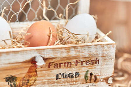 Fressh farm eggs in a wooden eggs box with straw