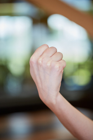 Caucasian young woman showing fist as symbol for strongness