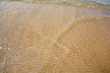 Little ripples in the sand from the sea on the beachの写真素材