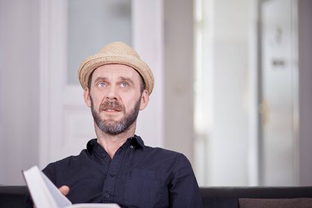 White male man with book sitting and looking up copyspaceの写真素材