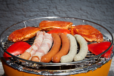 Barbecue grill with meat and sausages and smokeの写真素材