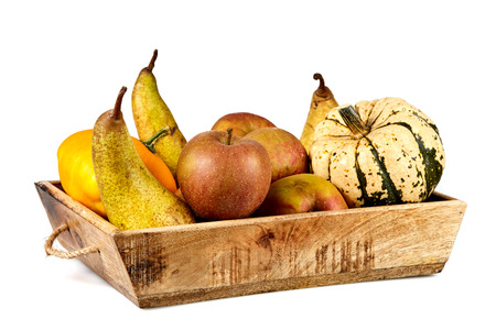 Isolated basket full of autumn fruits with apples, pears and pumpkinの写真素材