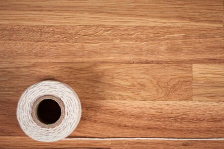 Cord, string or rope on a brown wooden oiled oak plateの写真素材