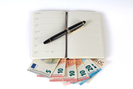 Earning money with writing symbolized with pen and notebook on euro money banknotesの写真素材