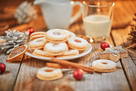 Christmas cookies and glass of milk on a brown wooden table with white sugarの写真素材