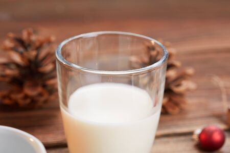 Glas of milk and pine cones on wooden table for christmasの写真素材