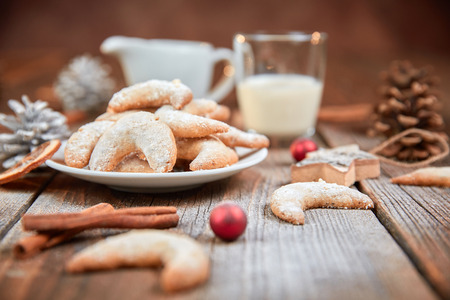 Vanilla horse shoe cookies on wooden table with red christmas ballsの写真素材