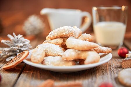 Glass of milk and cookies on table with pine coneの写真素材