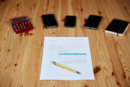 Contract with ballpoint and mobile phones on a wooden tableの写真素材