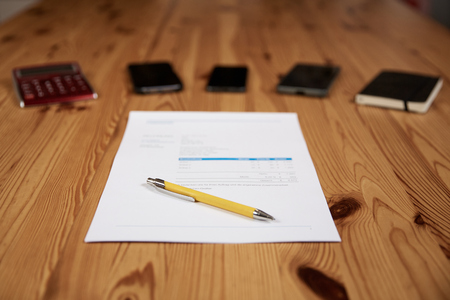 Contract with ballpoint and mobile phones on a wooden tableの写真素材