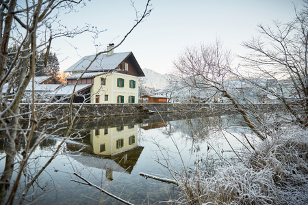 House at the river with frost and ice on plants on a sunny morningの写真素材