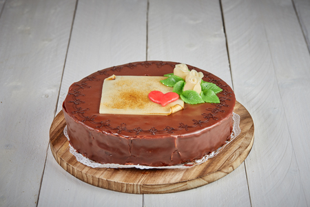 Birthday Sacher cake with chocolate and marzipan on white wooden tableの写真素材