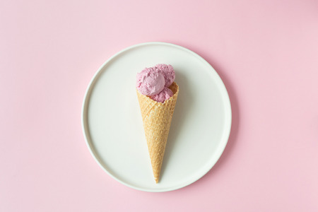 Flatlay of pink ice cream scoops, sweet cones and peonies over pastel pink background. Top view with space for your textの写真素材