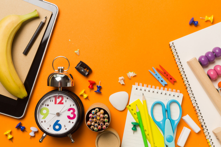 Back to school concept with clock color chalk pencil apple notebook over chalkboard background. Copy space. Top view. Flat layの写真素材