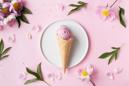 Spring or summer mood concept. Flat-lay of waffle sweet cone with berryy over pastel light pink background, top view.の写真素材