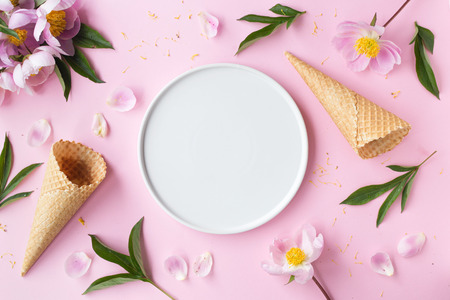 Spring or summer mood concept. Flat-lay of waffle sweet cone with berryy over pastel light pink background, top viewの写真素材