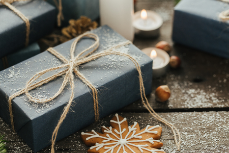 Festive Gifts with Boxes, Candle, Snow, Coniferous, Basket, Cinnamon, Pine Cones, Nuts on Wooden Background. With space for your textの写真素材