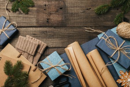 Packing christmas gifts in vintage beige blue roll paper on old wooden desk. Top View. Copy space. Flat Lay.の写真素材