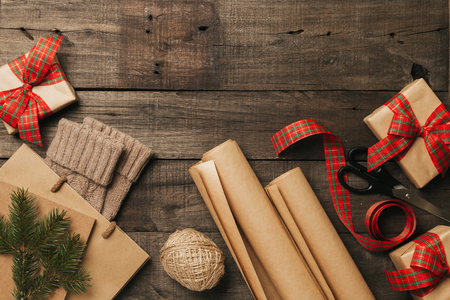Packing christmas gifts in vintage beige blue roll paper on old wooden desk. Top View. Copy space. Flat Lay.の写真素材