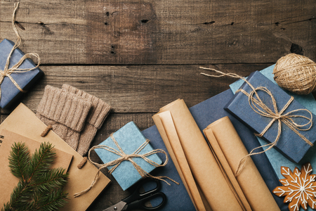 Packing christmas gifts in vintage beige blue roll paper on old wooden desk. Top View. Copy space. Flat Lay.の写真素材