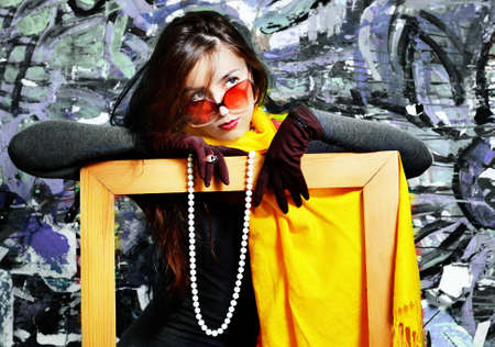 The girl with a beads and wearing spectacles on the abstract backgroundの写真素材