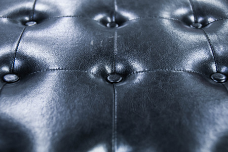 vintage style of leather couch with black color have many studs in square design on light and shadowの写真素材