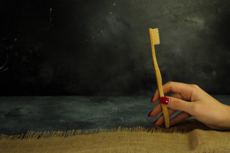 Woman hand holding eco-friendly bamboo toothbrushの写真素材