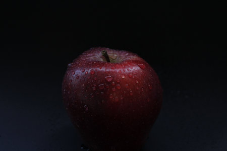 Water drops on red apple, dark backgroundの写真素材