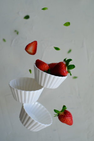 Strawberries in white bowls in levitationの写真素材