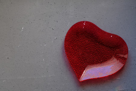A plate in the shape of a heart on grey backgroundの写真素材