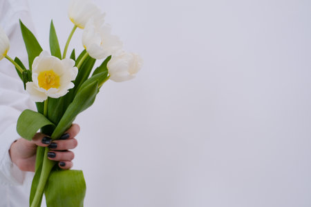 Bouquet of white tulips on womans hand, closeupの写真素材