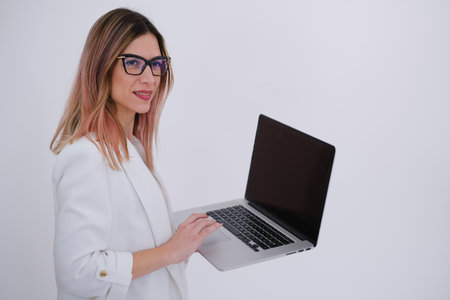 Business woman in white jacket, holding a laptop. White background. Copy space