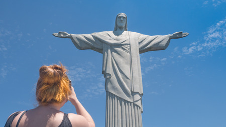 Rio de Janeiro, Brazil - September 18, 2016: A Tourists takes a photo at the Christ the Redeemer statue atop the Corcovado Mountain in Rio de Janeiro, Brazil.のeditorial素材