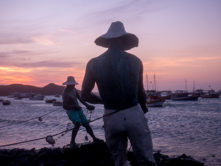 BUZIOS, BRAZIL - OCTOBER 24: Fisher Men monument at Sunset in Buzios. Rio de Janeiro, Brazilのeditorial素材