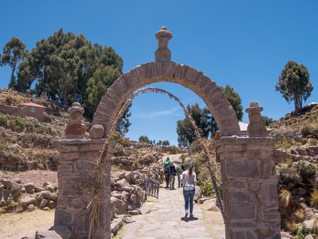 PUNO, PERU - NOVEMBER 14, 2016: Tourists walk in the gate of Taquile island in Puno, Peruのeditorial素材